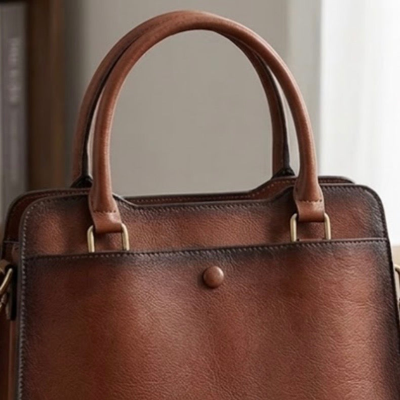 Heritage Burnished Leather Tote - Deep mahogany by TIKORI LONDON. Bag top handle showing in the picture with golden tone hardware. 