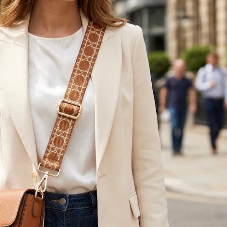 TIKORI LONDON checkered lines tan crossbody strap laid flat showing pattern and adjustable length. Golden hardware showing in a white background. Body of a model wearing a cross body bag and this strap. Golden hardware is showing. Street background.