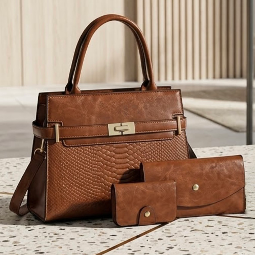 Terra embossed carryall tote tan by TIKORI LONDON. The upper half featured a smooth polished texture, while the lower half features a luxurious, deep embossed reptilian texture for a high contrast in premium high quality Vegan Leather. Bag displaying with matching wallets and card holder next to it. Mabel display. 