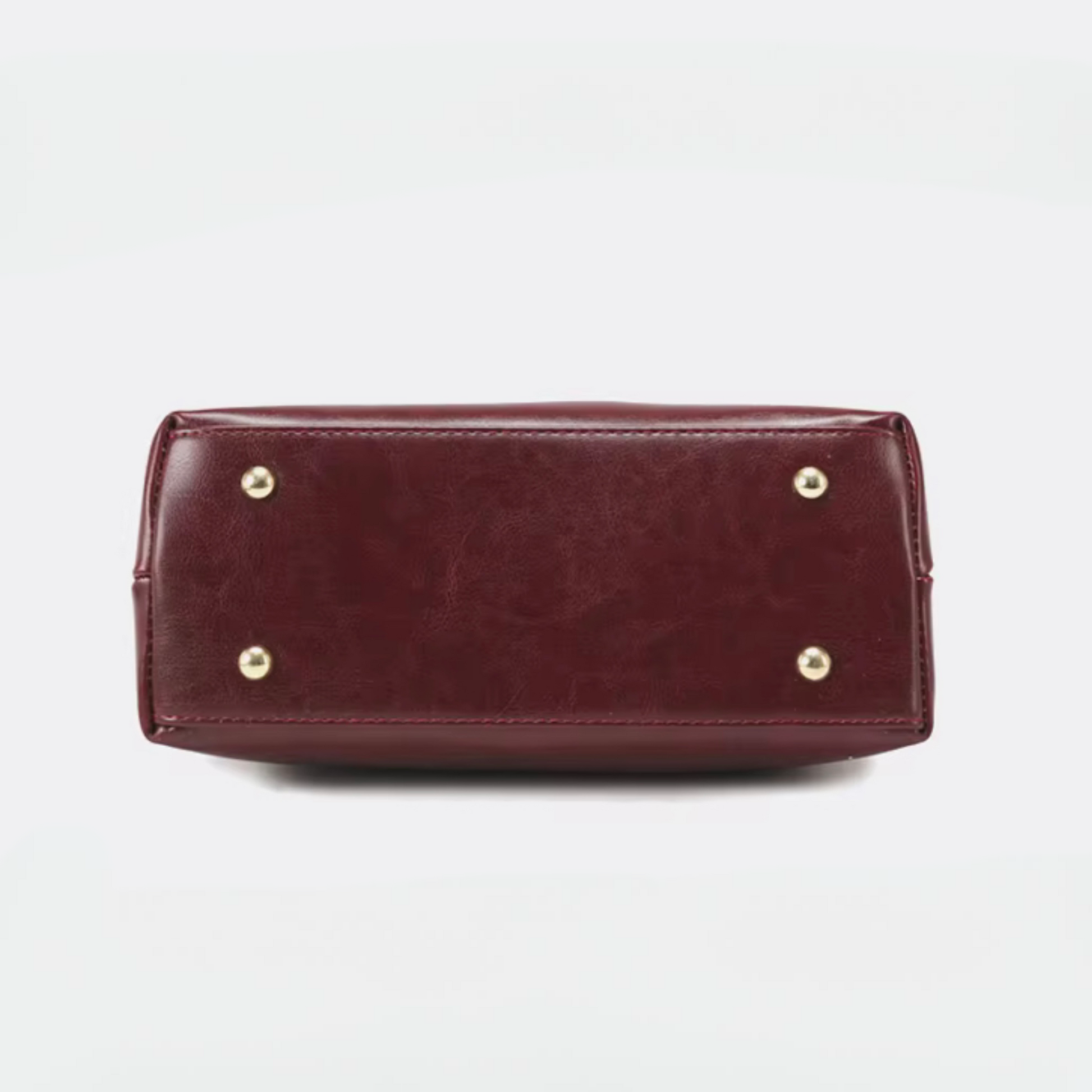 Heritage Flap Bag - Maroon By TIKORI London. Featuring bottom of the handbag showing in the picture with gold legs.
