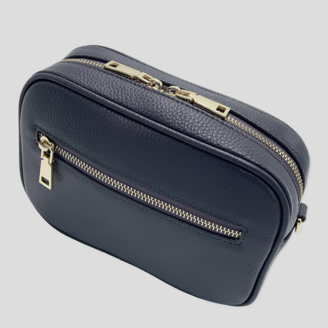 Classic elegance with practicality and versatility in mind. TIKORI classic grey purple by TIKORI London. Crossbody bag Crafted in soft pebbled premium genuine leather. Front profile of the bag showing golden hardware and front pocket with zipper details in white background  