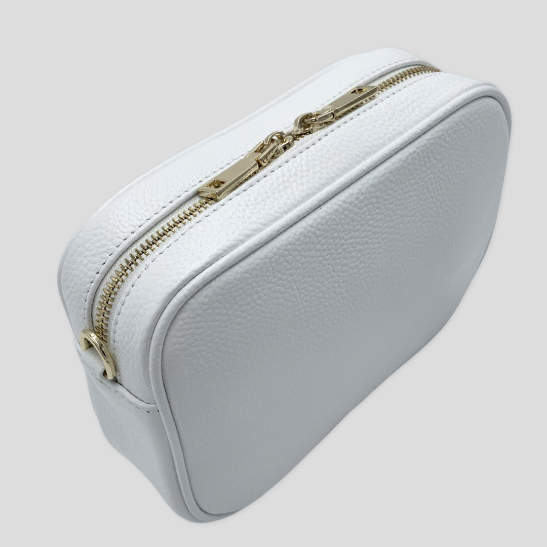 Classic elegance. Tikori Classic White by TIKORI london.  Genuine pebbled leather cross body bag. Back profile of the bag showing the zipper details, gold hardware in white background.