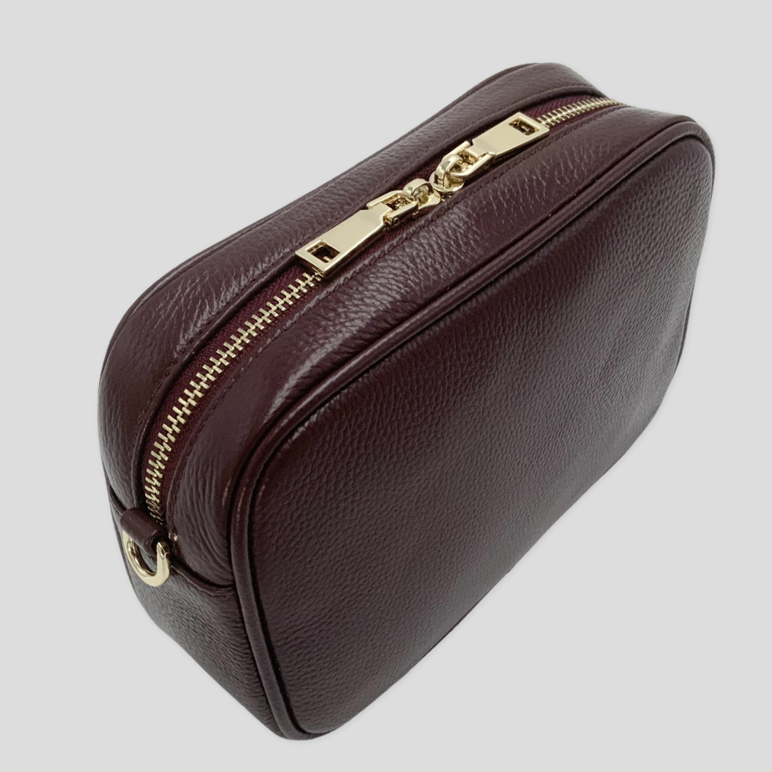 Classic elegance with practicality and versatility in mind. TIKORI classic maroon by TIKORI london. Genuine Leather crossbody bag. Side and back  profile of the bag showing with golden tone hardware  in white background. 