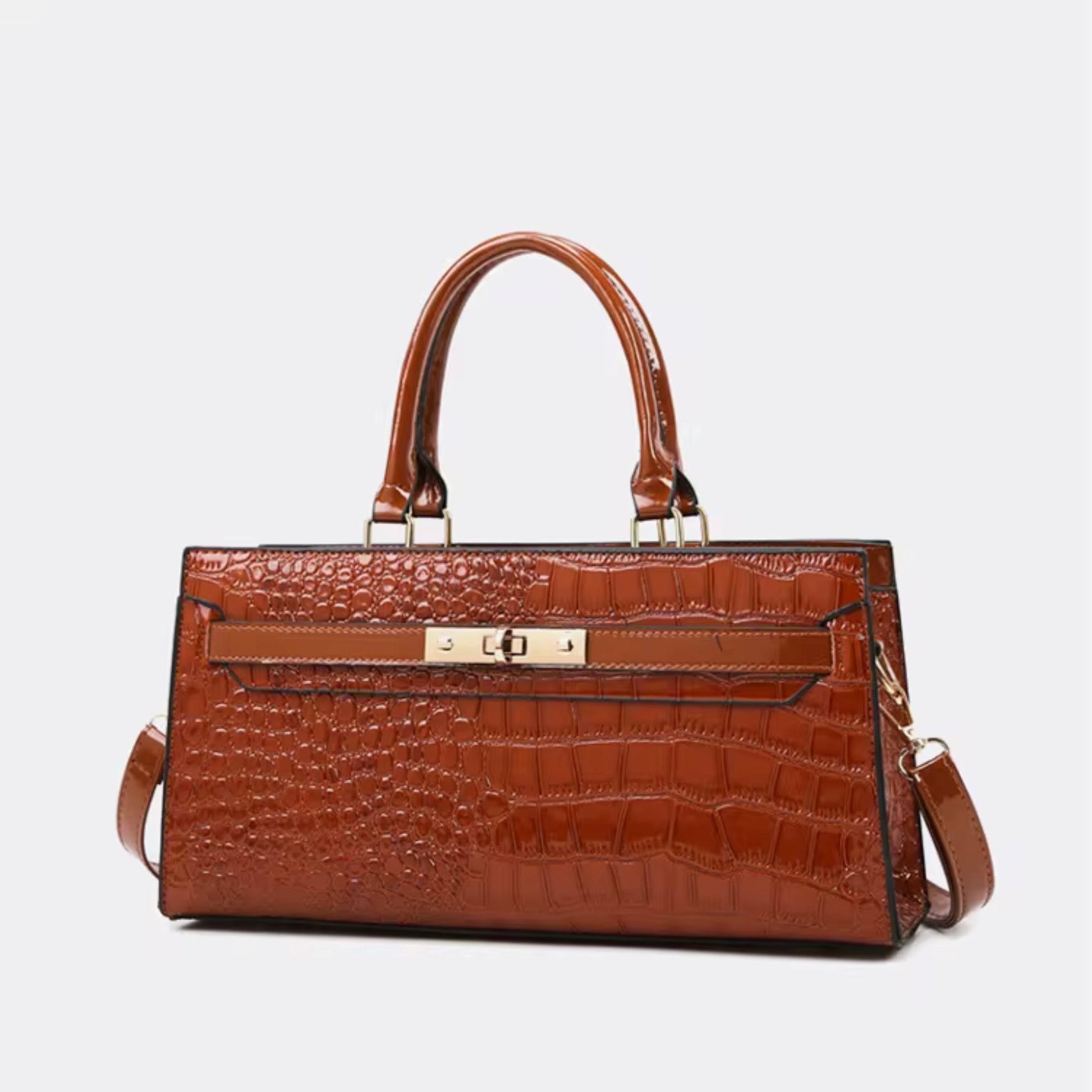 Gilded Croc Baguette shoulder bag Cognac By TIKORI London. Front golden lock detail showing on the picture. Top handles detail with Golden tone hardware. Bag displaying in a fully white background.