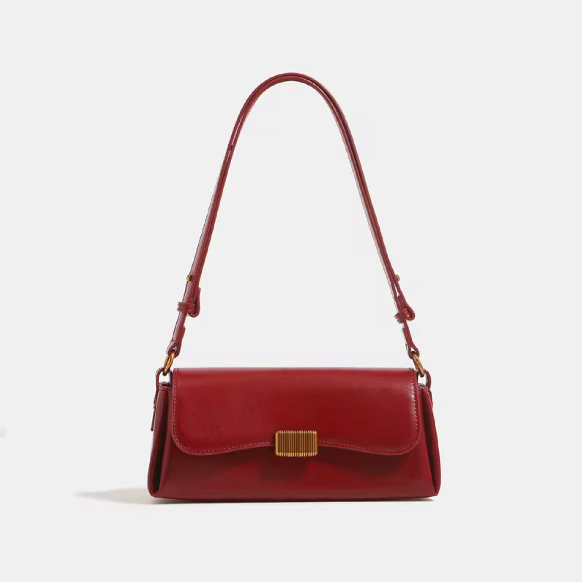 Crimson Muse Shoulder Bag - Red  by TIKORI LONDON. Features a structured, elongated "baguette" body with clean, sharp lines and a narrow profile designed to sit snugly under the arm. Picture shows the front profile of the bag with top handle.