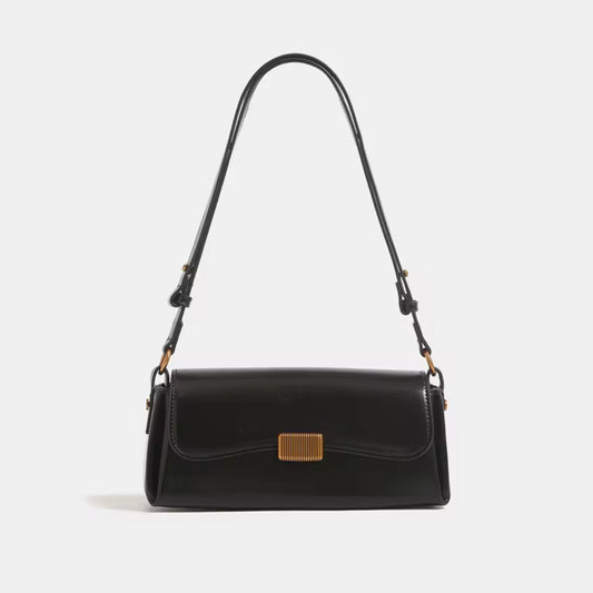Crimson Muse Shoulder Bag - Black by TIKORI LONDON. Features a structured, elongated "baguette" body with clean, sharp lines and a narrow profile designed to sit snugly under the arm. Picture shows the front profile of the bag with top handle.
