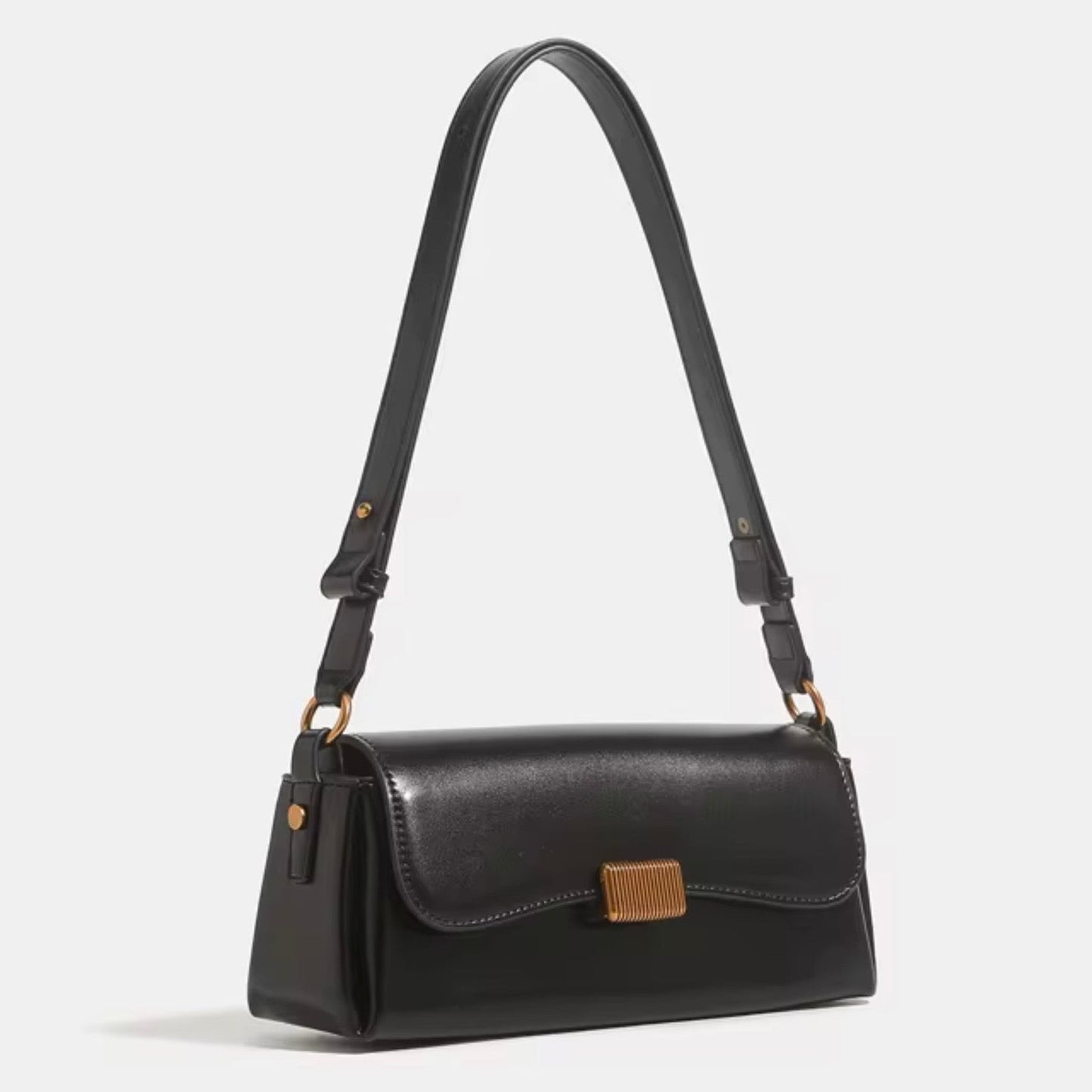 Crimson Muse Shoulder Bag - Black by TIKORI LONDON. Features a structured, elongated "baguette" body with clean, sharp lines and a narrow profile designed to sit snugly under the arm. Picture shows the angle profile of the bag with top handle.