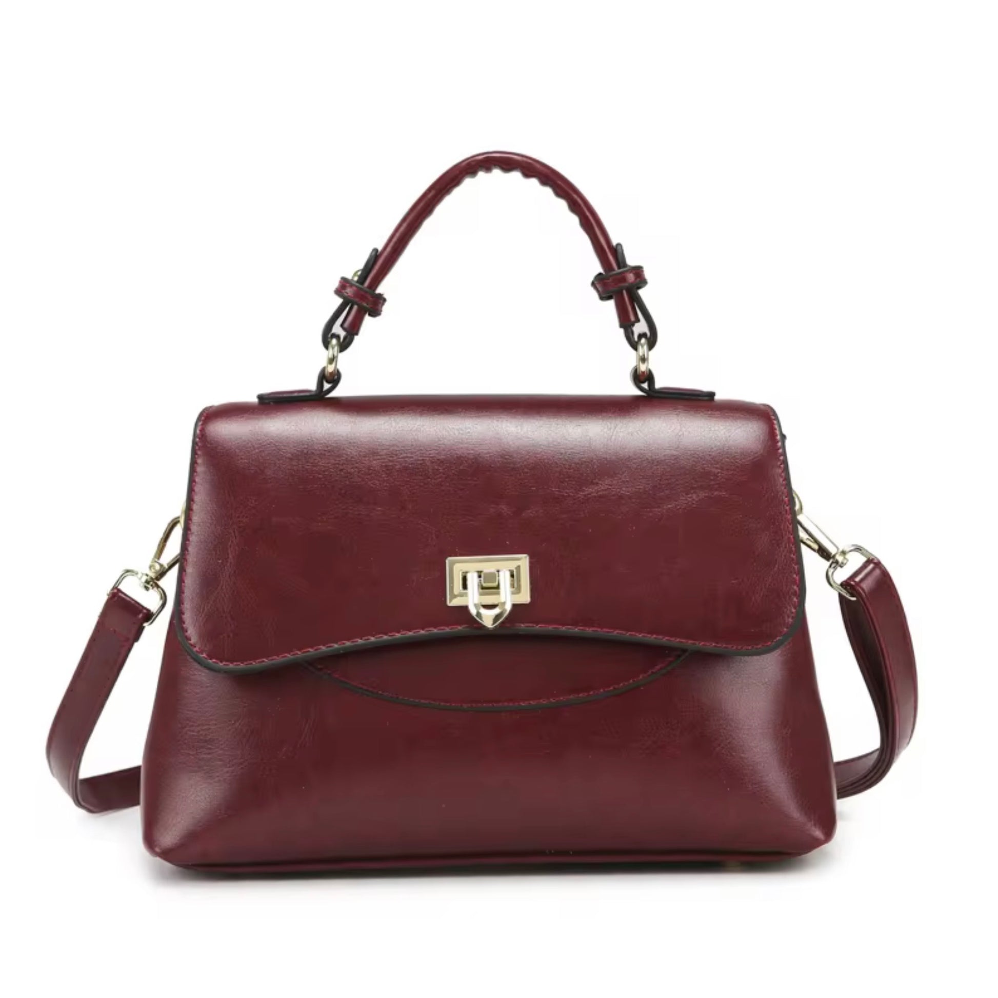 Heritage Flap Bag - Maroon By TIKORI London. Features a beautiful, sweeping front flap secured by a polished, shield shaped gold clasp. Top handle and long strap included. Front of the bag showing on the picture.