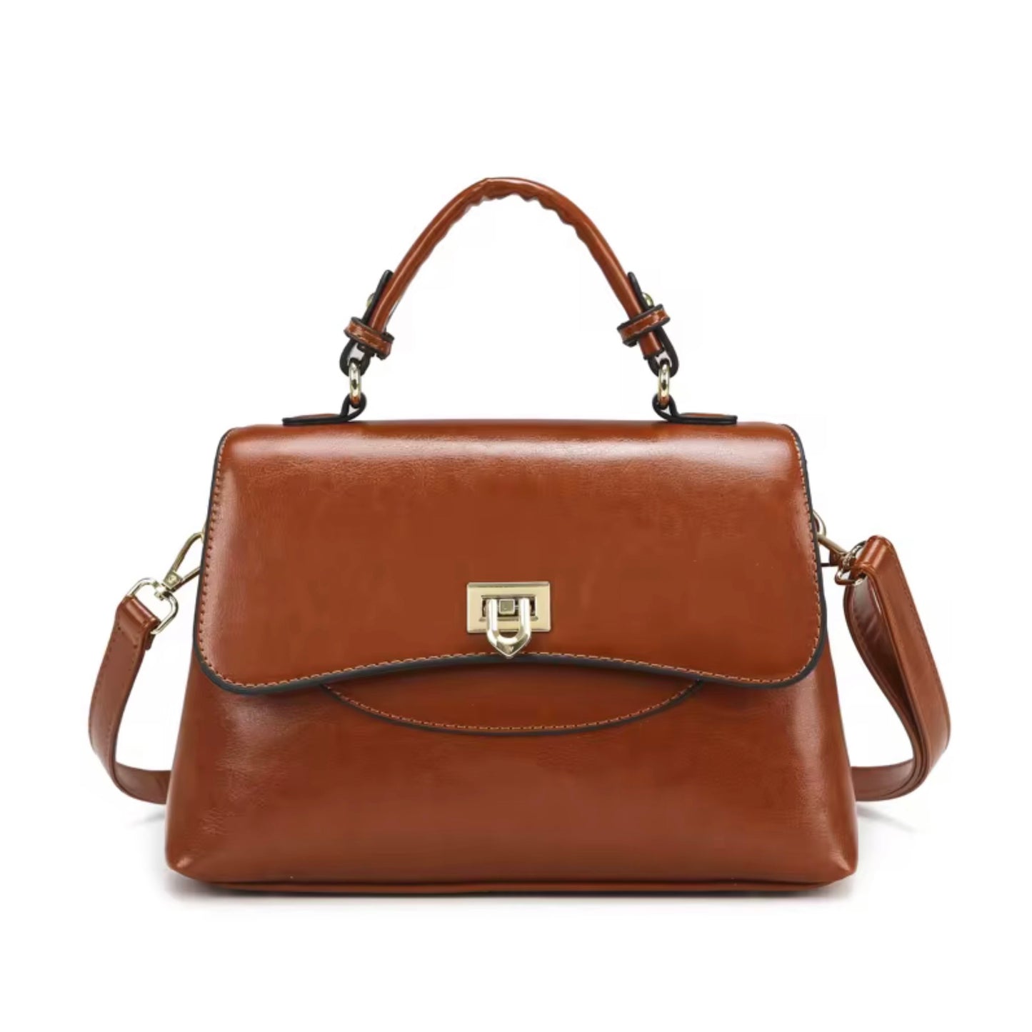 Heritage Flap Bag - Tan  By TIKORI London. Features a beautiful, sweeping front flap secured by a polished, shield shaped gold clasp. Top handle and long strap included. Front of the bag showing on the picture.