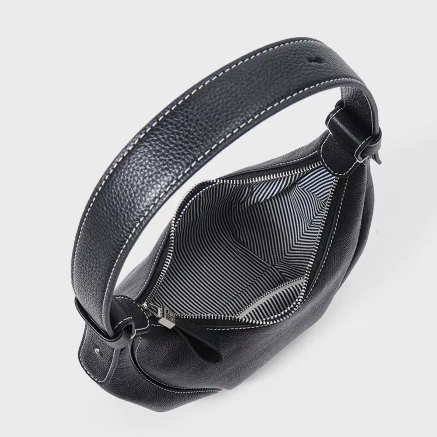 Ellipse Crescent Hobo Bag - Black by TIKORI LONDON. Zipper open, showing inside of the bag. Sleek design with silver hardware.