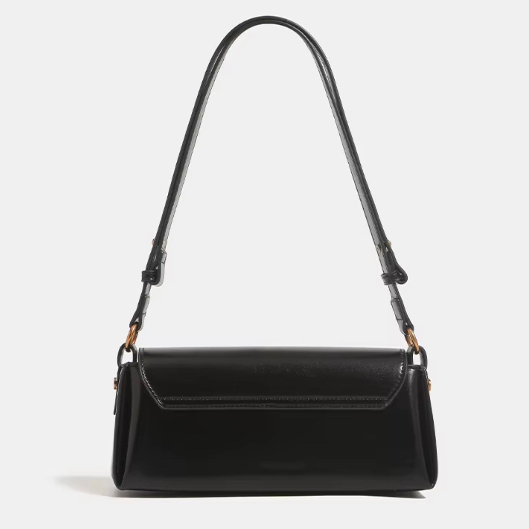 Crimson Muse Shoulder Bag - Black by TIKORI LONDON. Features a structured, elongated "baguette" body with clean, sharp lines and a narrow profile designed to sit snugly under the arm. Picture shows the back profile of the bag with top handle.