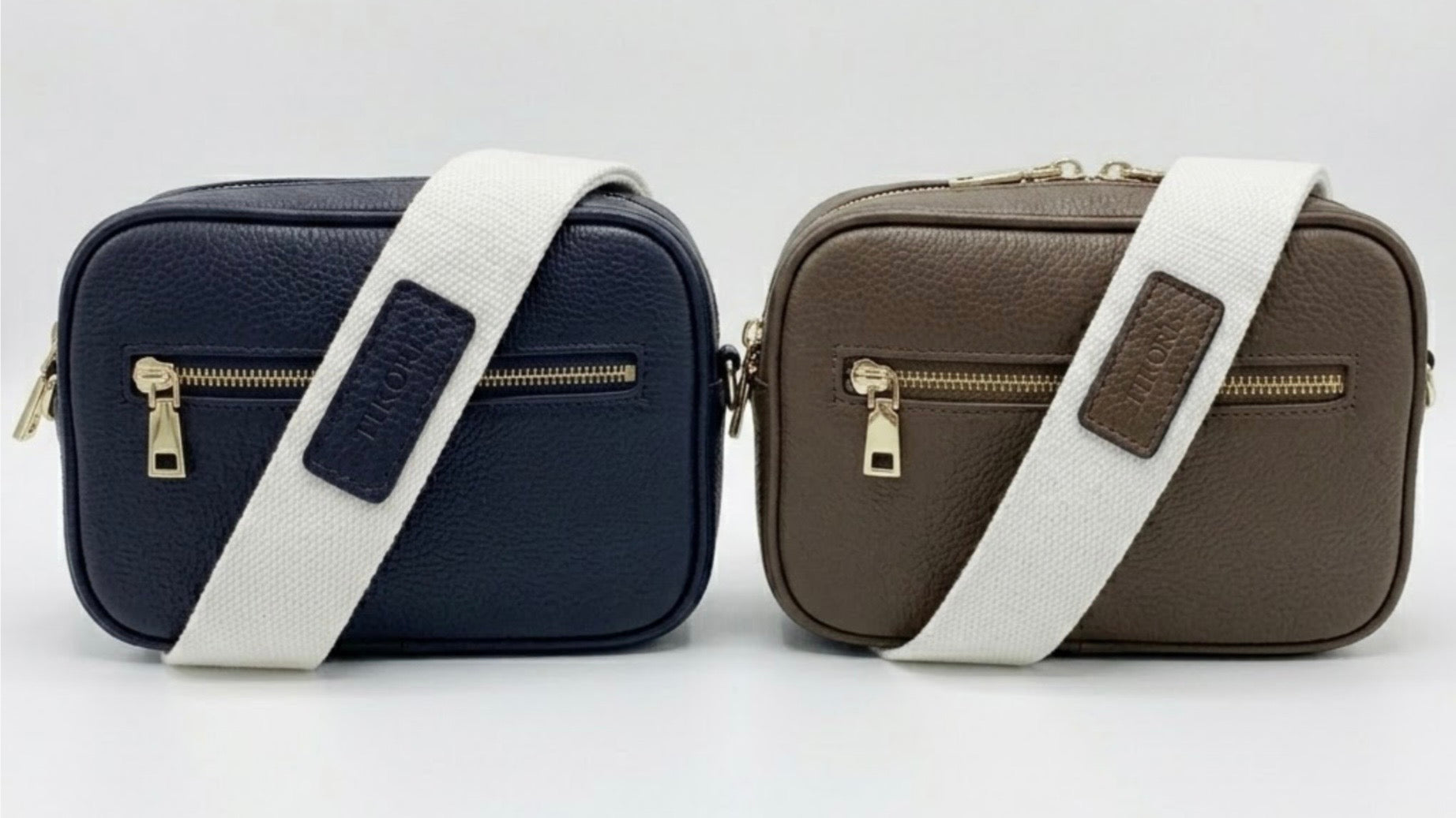 TIKORI classic Navy  and Taupe by TIKORI London. Classic elegance with practicality and versatility in mind. Taupe and white leather cross body bag shows in the picture with golden tone hardware and TIKORI canvas strap. Front profile includes the gold zipper pocket. Bag display in a white background.  