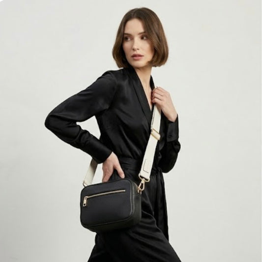 Classic elegance with practicality and versatility in mind. TIKORI classic Black by TIKORI london. Model in black cloth wear the black crossbody. Front profile of the bag showing with golden tone hardware. Front pocket and close up detail of the pocket shows in fully ivory background.