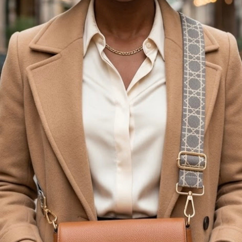 Grey  Tikori London Checkered Lines Crossbody Strap with adjustable length laid and stylish pattern displayed. Dark skinned model wearing crossbody bag has this strap. Golden hardware also showing in the picture in a street background. 