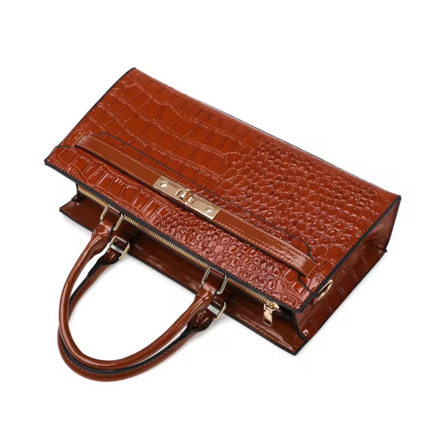 Gilded Croc Baguette Shoulder Bag cognac by TIKORI LONDON. Designed with a structured architectural frame and a glossy crocodile-embossed finish, it brings a "quiet luxury" aesthetic to your wardrobe at a fraction of the cost. Bag laid on the floor showing the front profile golden hardware curved handles in a fully white background.