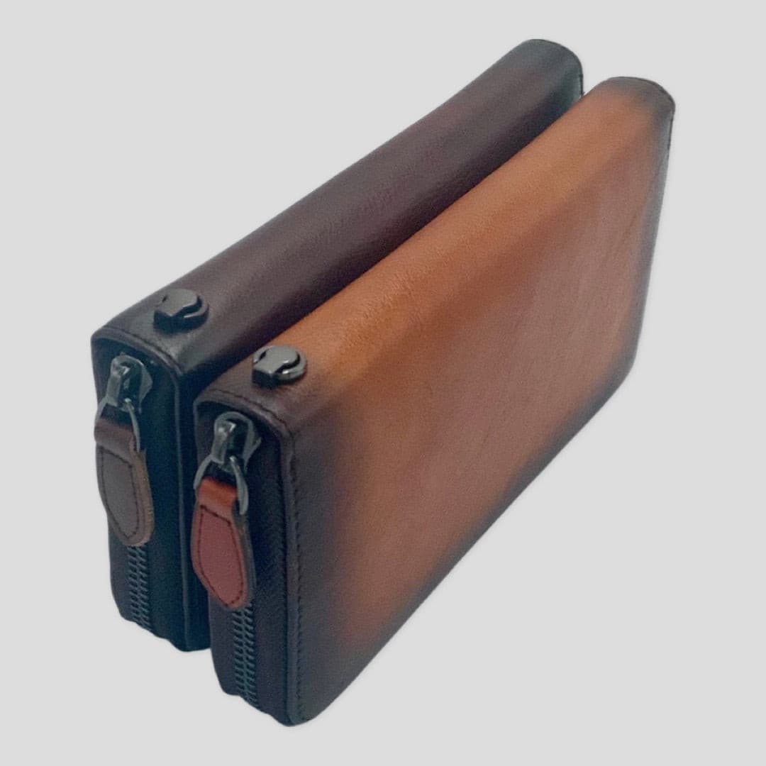 Dark brown Tikori London wrist strap wallet with compact design and metal clasp, showing the leather exterior and strap details. Dark brown nd orange brown both showing.