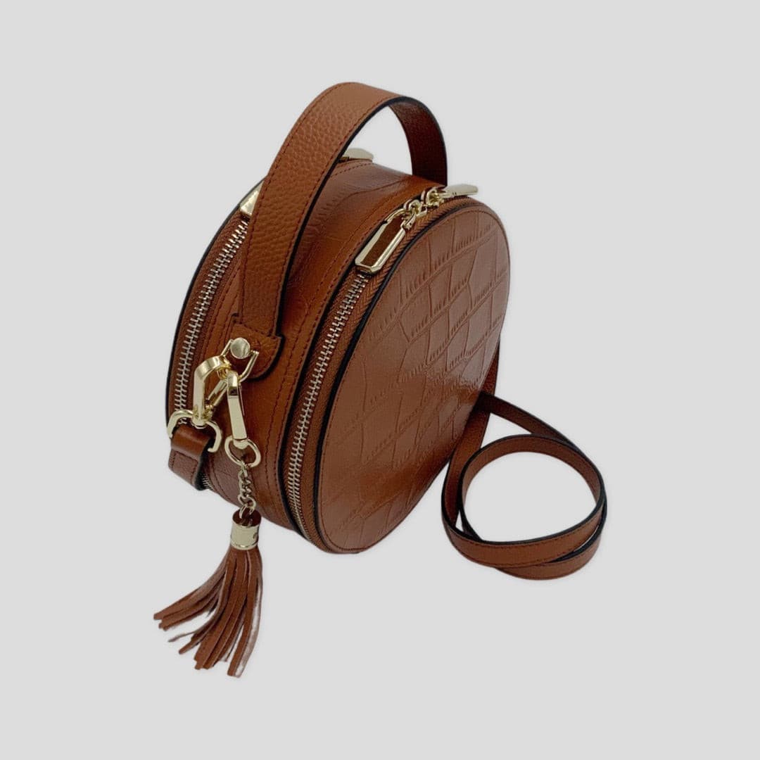 Cleopatra by TIKORI London. warm tan leather circle crossbody bag with dual zip fastening, stylish and compact for everyday use.
