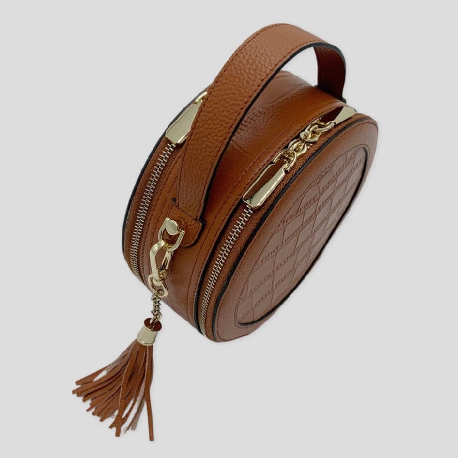 Cleopatra by TIKORI London. warm tan leather circle crossbody bag with dual zip fastening and finished leather details.