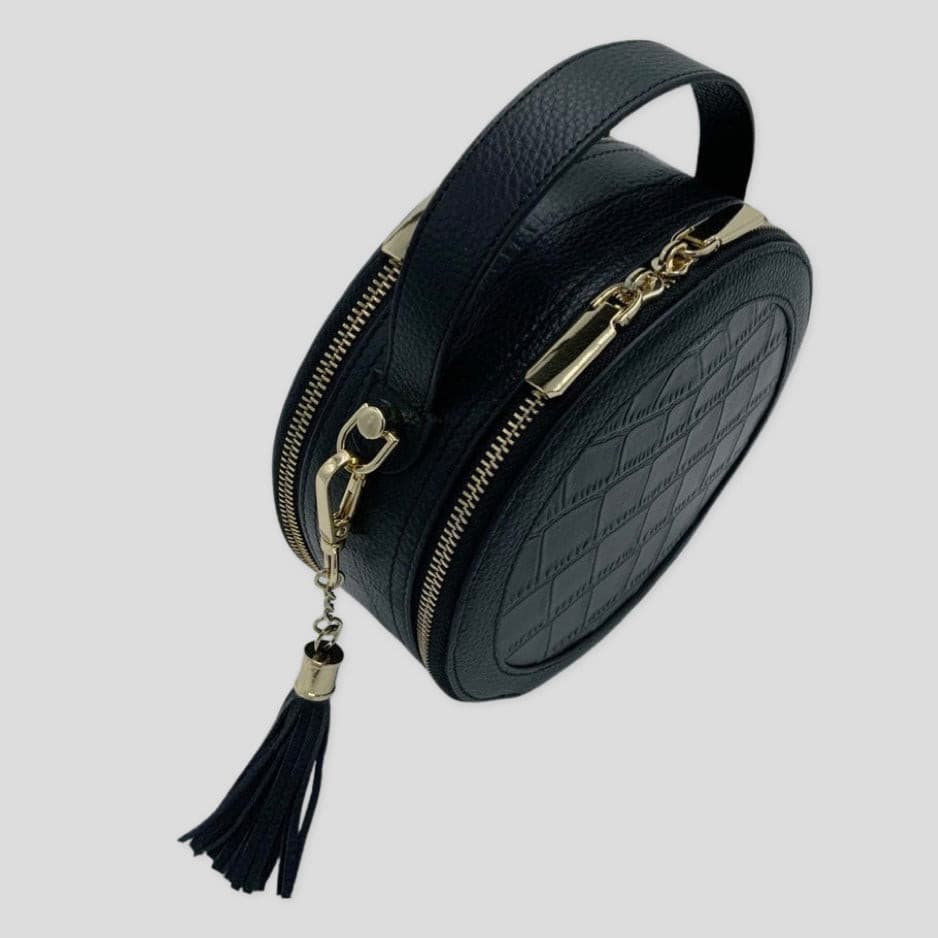 TIKORI LONDON black finished leather circle crossbody bag with dual zip fastenings, featuring a sleek, rounded design.