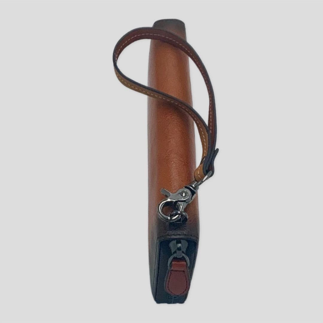 Tikori London wrist strap wallet in orange and brown leather, featuring a compact design with a wrist strap for easy carrying.