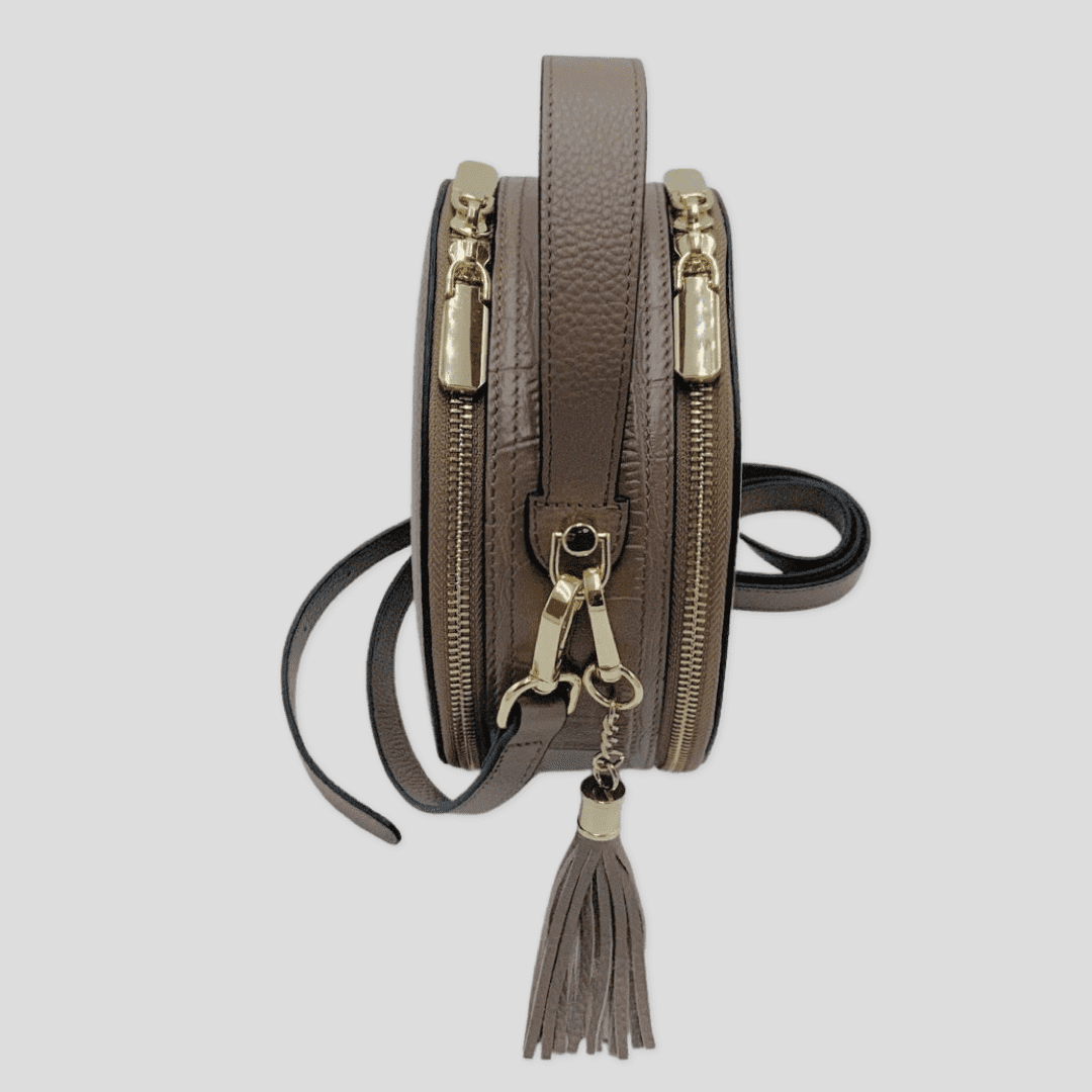 Cleopatra by TIKORI London. Mink leather circle crossbody bag with dual zip fastening, stylish and compact for everyday use. Side profile of the bag showing in the picture.